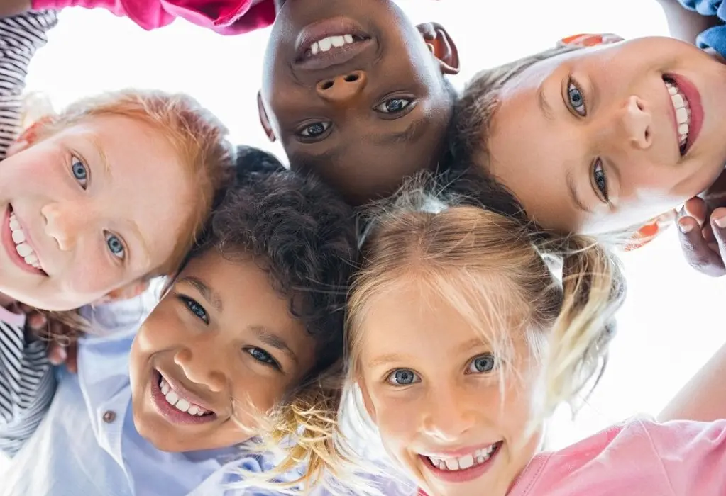 A group of children are smiling for the camera.